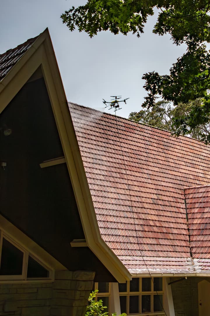 Drone performing roof treatment spraying