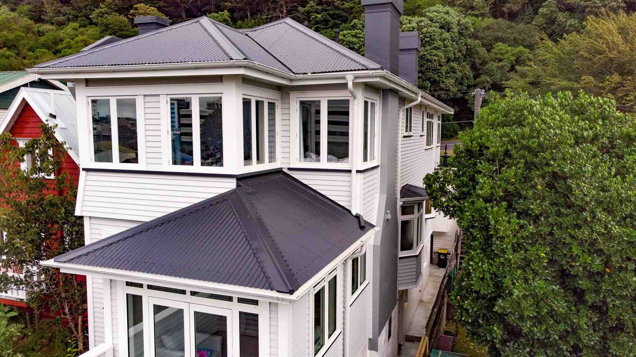 Person cleaning a gutter off a ladder