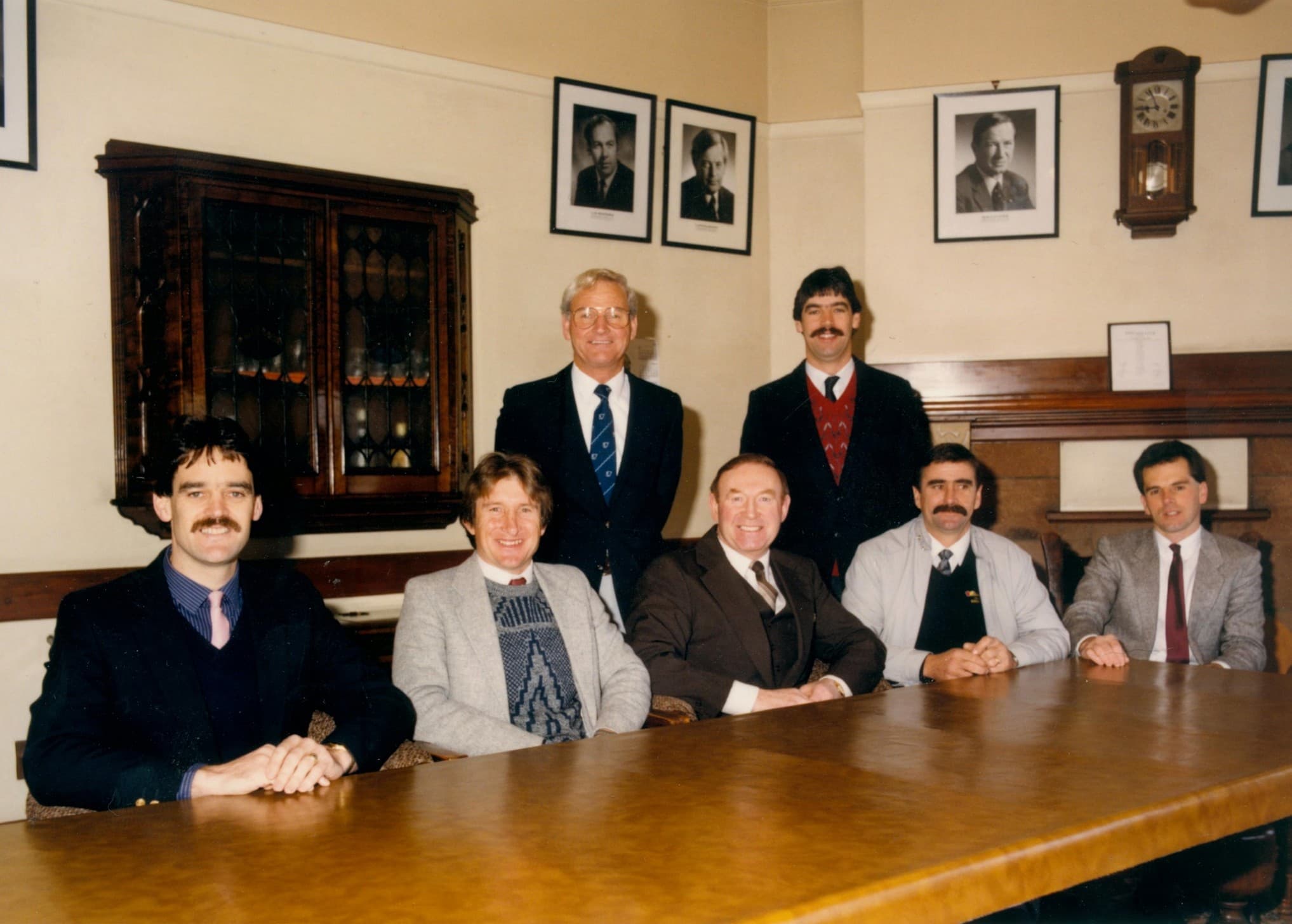 Edwards & Hardy managers seated and standing around a conference table