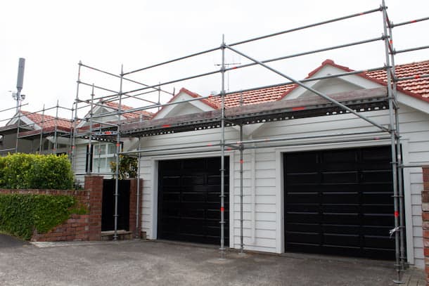 Scaffolding and roof access set up for a reroofing project with hidden structural work