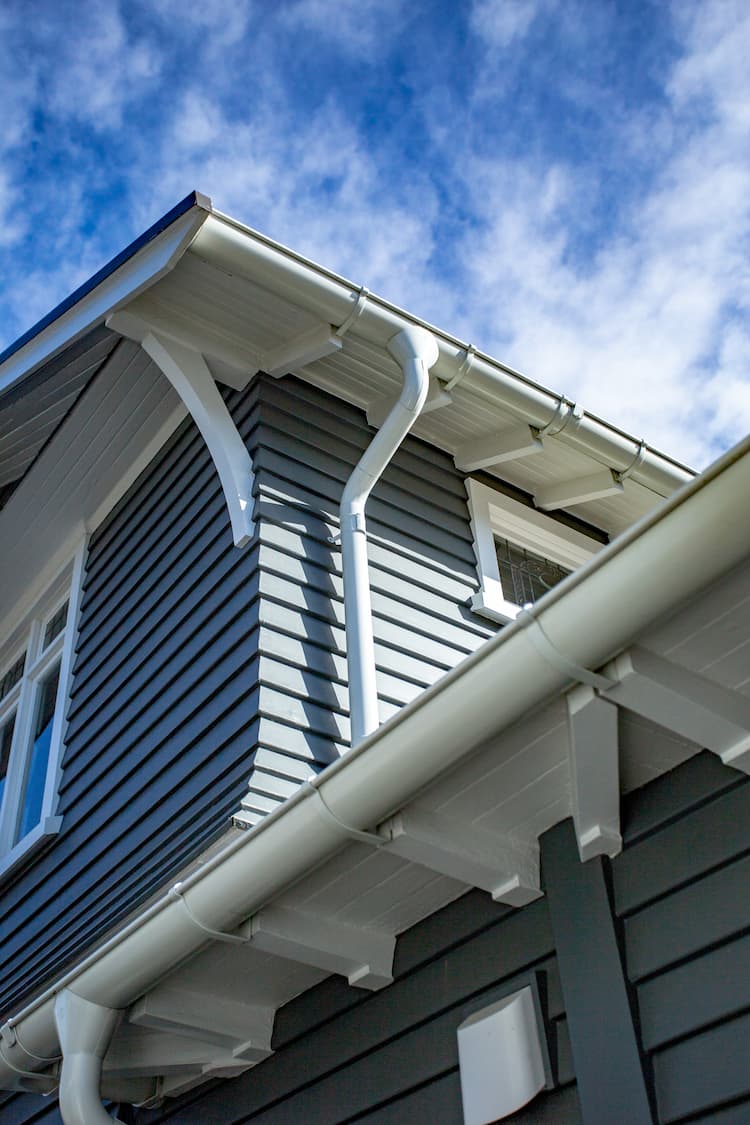 A house with a sloping roof and a gutter for rainwater drainage.