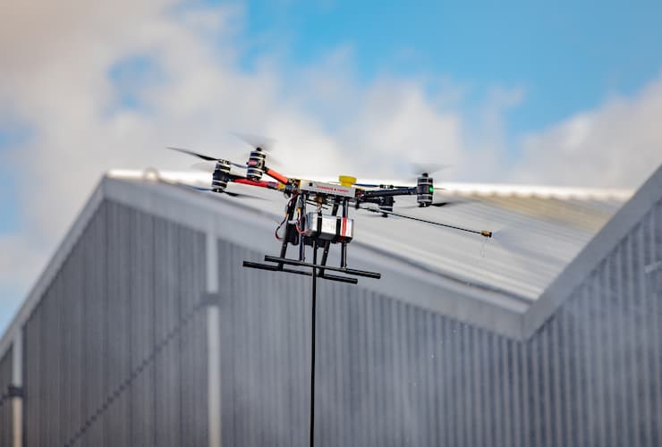 A drone hovering in front of a building.