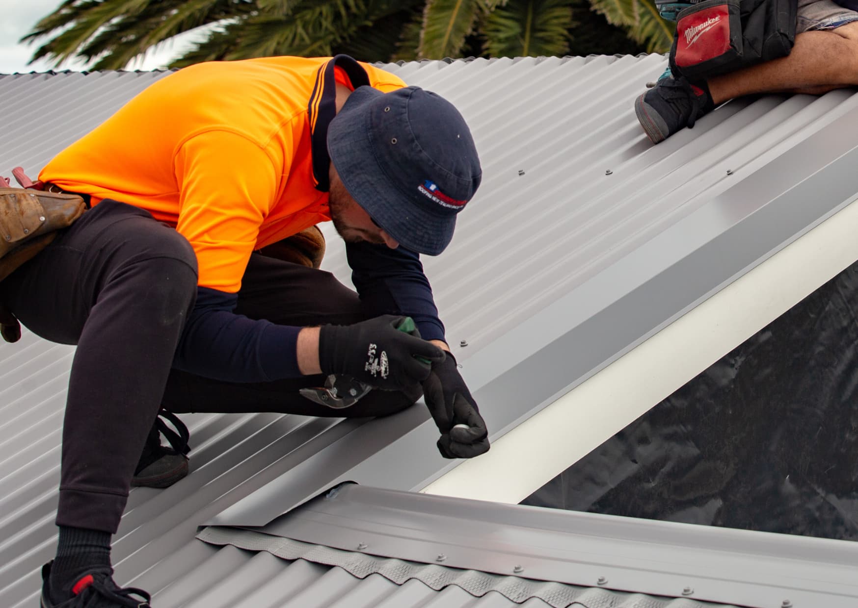 Edwards & Hardy roofing specialist conducting an on-roof inspection on a metal roof