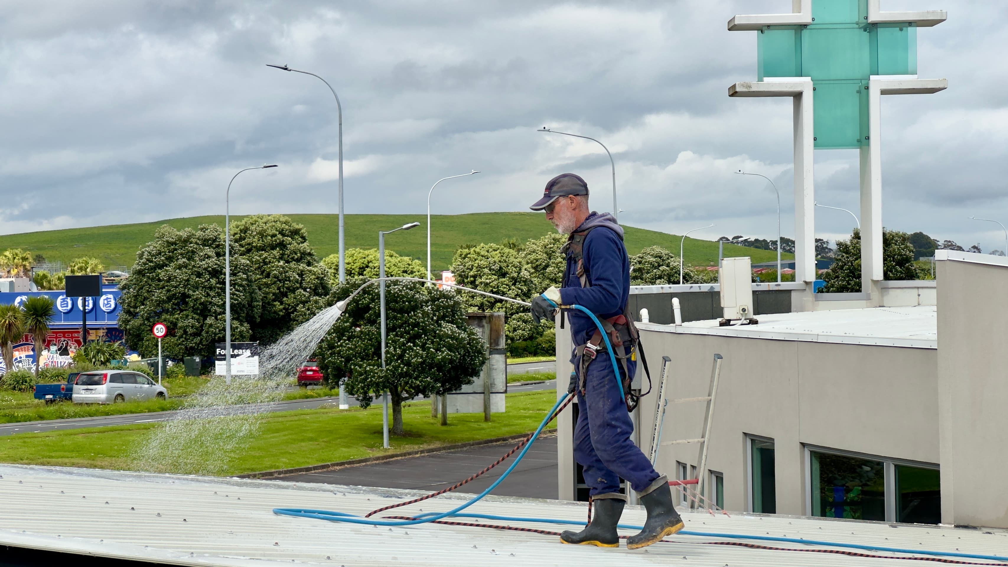 Person using an extendable gutter cleaning tool to clean gutters from the ground